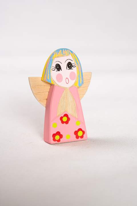 Anioł z drewna, duży, z różowym tułowiem w czerwone kwiatki z żółtymi kropkami włosy niebiesko żółte