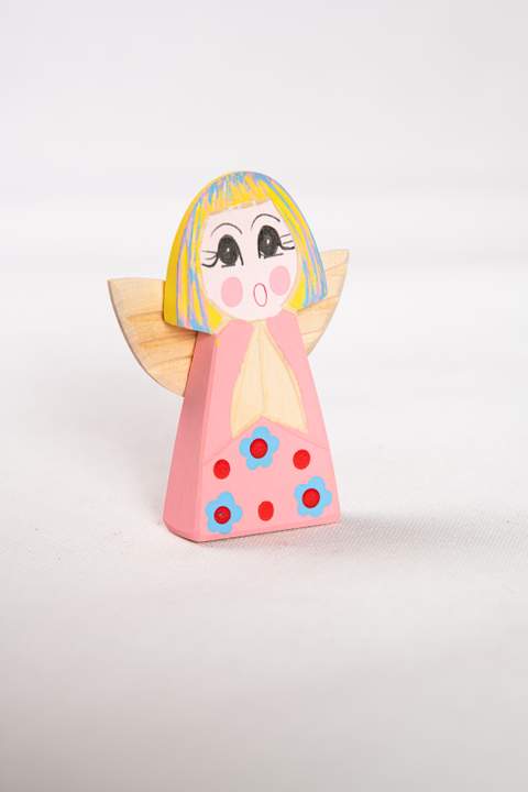 Drewniany anioł, duży, z różowym tułowiem w niebieskie kwiatki z czerwonymi środkami, wyraźne czerwone kropki, włosy żółto niebieskie