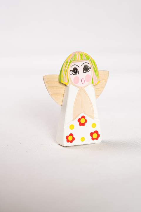 Drewniany anioł, duży, biały tułów w czerwone kwiatki z żółtymi kropkami włosy zielono różowe