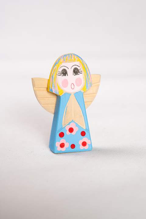 Drewniany anioł, duży, z niebieskim tułowiem w różowe kwiatki z czerwonymi środkami włosy żółto niebieskie