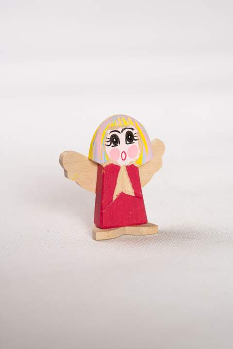 Drewniany anioł, mały, bordowy tułów z jasnymi skrzydełkami i niebiesko różowymi włosami