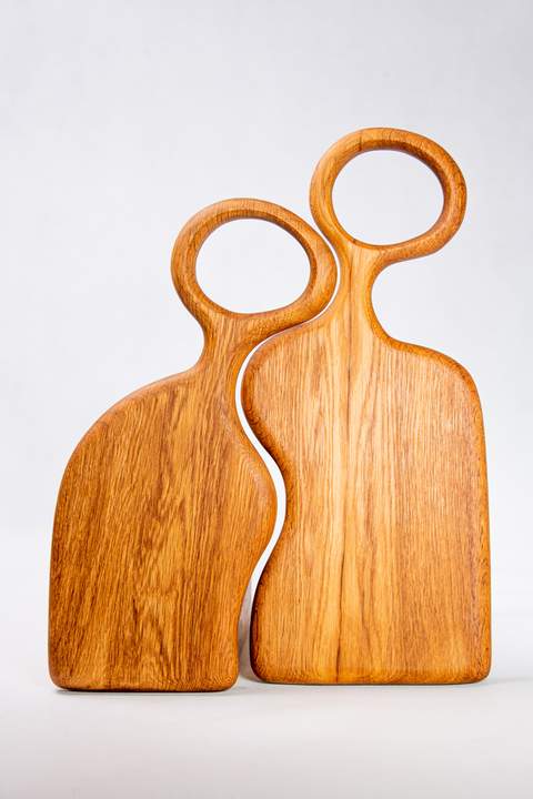 Drewniany zestaw deskek do serwowania, w kolorze ciemnego brązu, wycięte boki w kształcie fali, rączki długie z okrągłymi otworami, wyraźne mahoniowe słoje