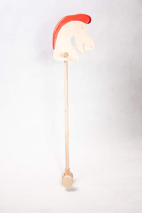 Drewniany koń na patyku, z grzywą w kolorze intensywnej czerwieni