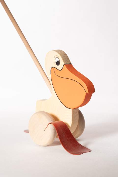 Ptak z drewna, pelikan na kiju z dużym, pomarańczowym dziobem, czarne oko, dwie brązowe płetwy