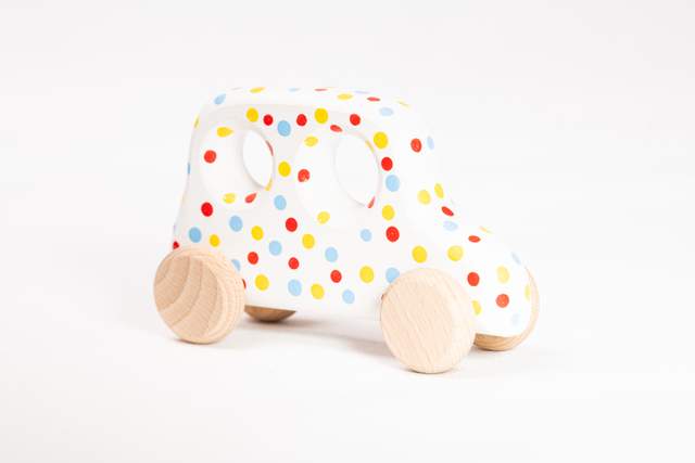 Samochód zabawka z drewna, średni, biały w czerwone, żółte i błękitne kropki,
z dwoma okienkami